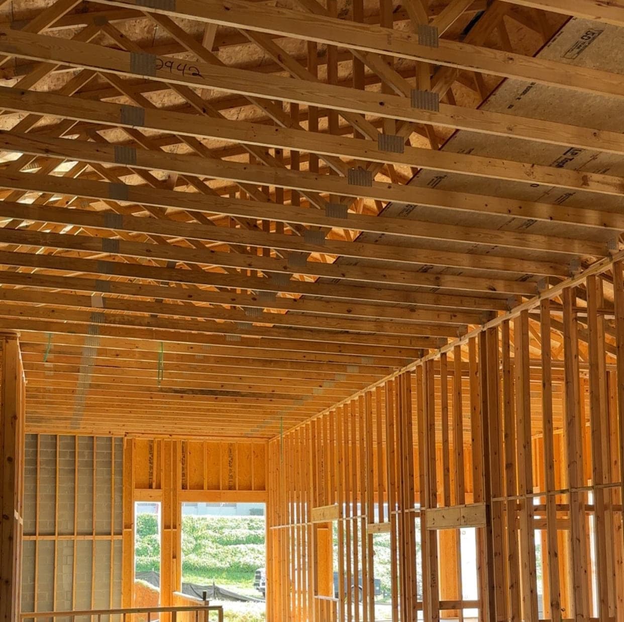 Interior of the Honeytree After School Learning Center in Roanoke, Virginia, under construction, with completed roof trusses overhead and stud walls framed out before the mechanical, electrical and plumbing work