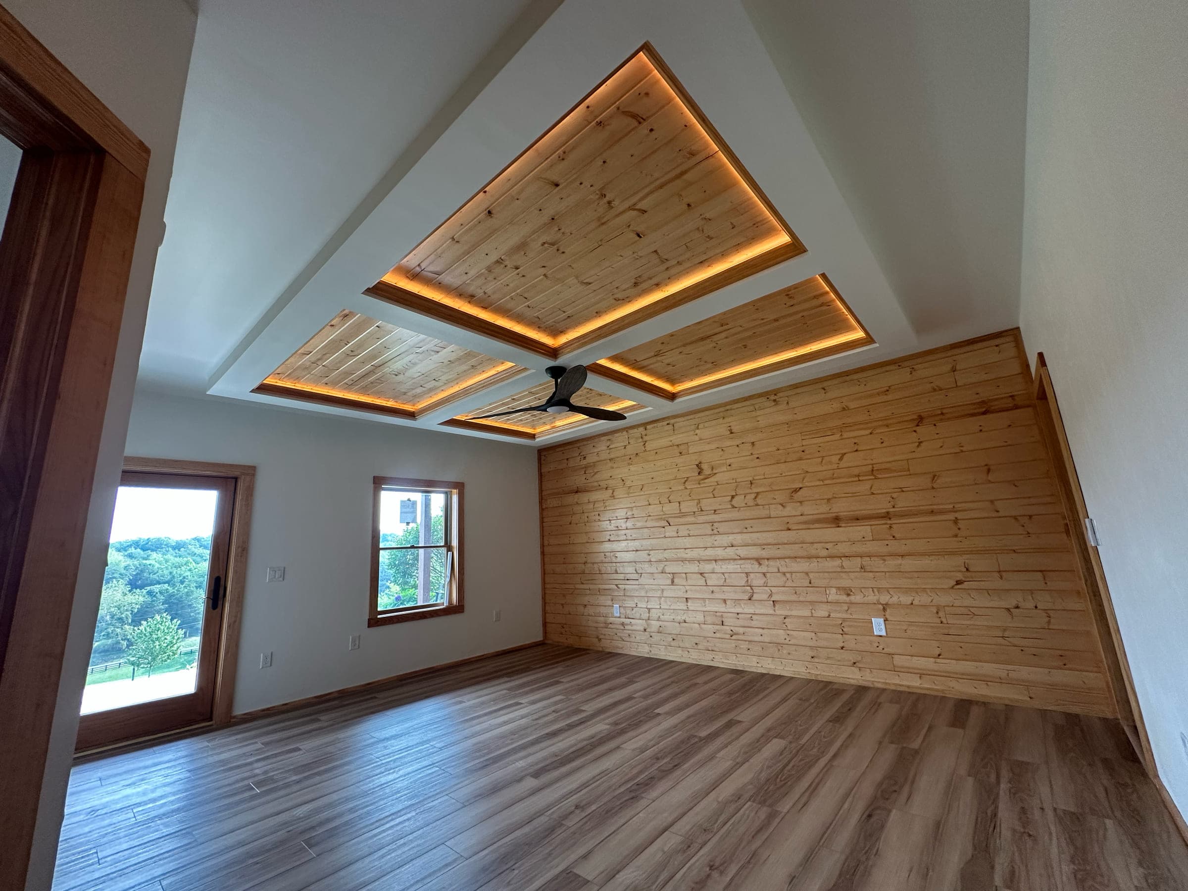Coffered pine ceiling with concealed cove lighting above a finished basement living space