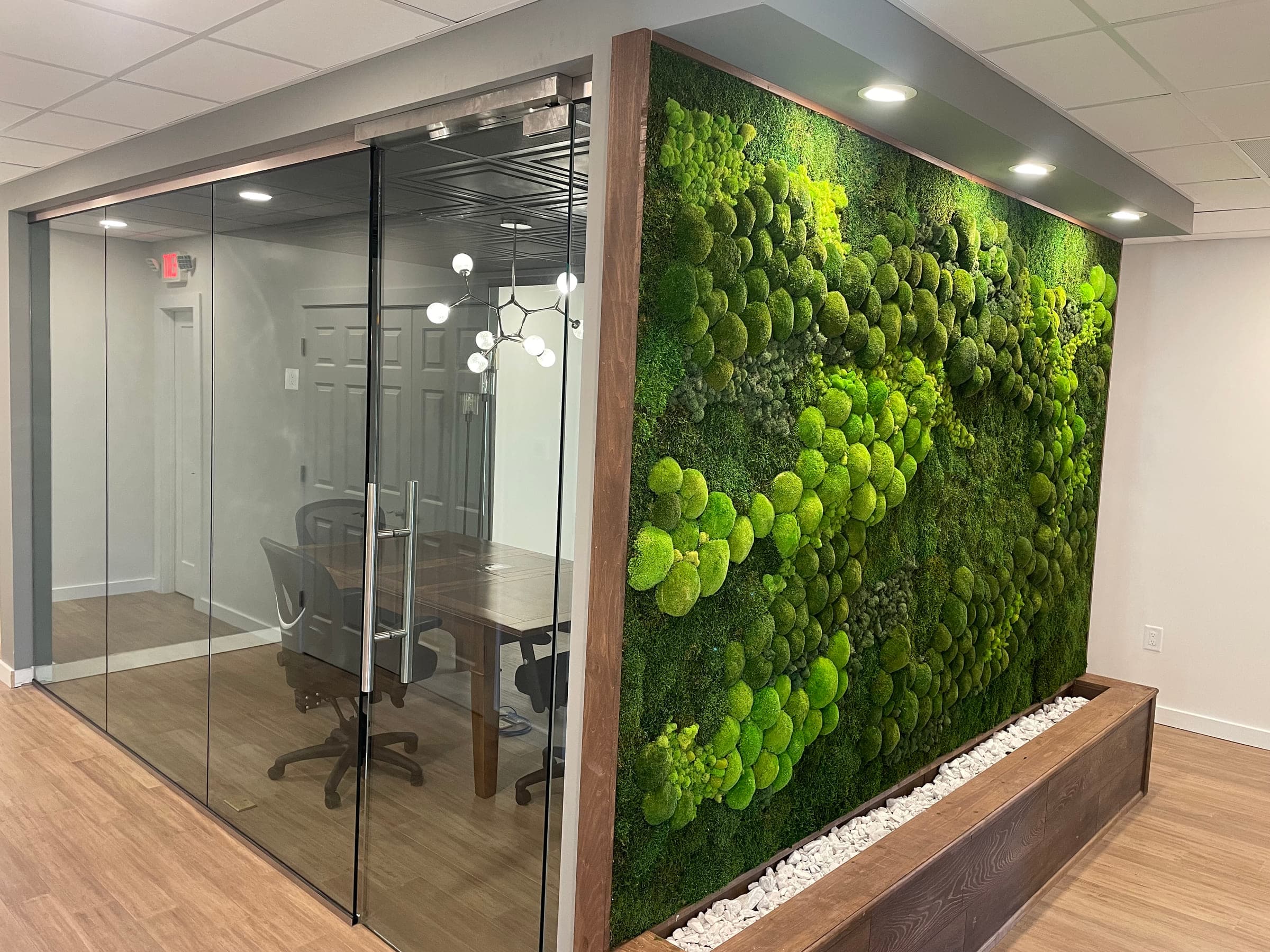 Walnut-framed moss wall beside a glass-walled conference room built inside a Roanoke County law office